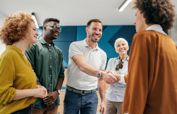 Diverse group of professionals shaking hands, symbolizing collaboration and connection.